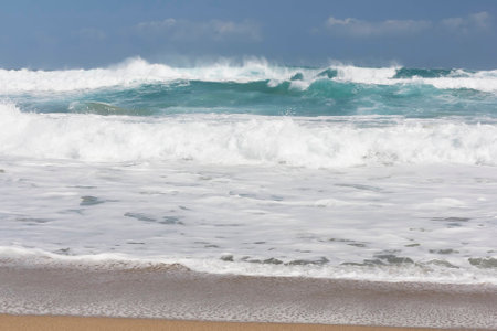Blue sky and blue sea. Waves, white clouds and sea foam, yellow sand beach.