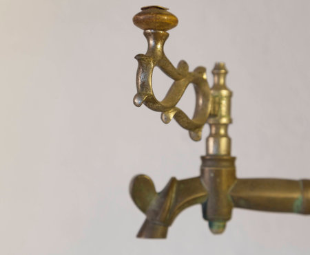 Old brass faucet of antique samovar on background white wall.の写真素材