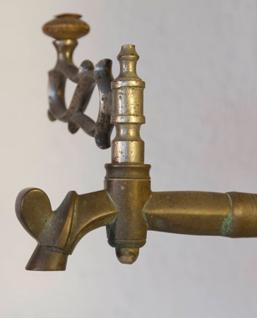 Old brass faucet of antique samovar on background white wall.の写真素材