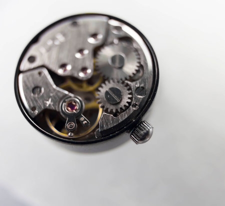 Open cover steel clockwork in black body on a white background. Clarity at the front and gradually...