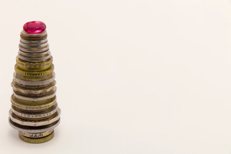 Column of coins with rubies in the form of a Christmas tree on a white background. Clarity in the middle column.の写真素材