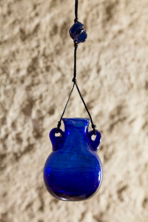 Jar of blue glass on the background of a concrete wall. Vintage bank. Extremely light. Bead glass on a shoestring.の写真素材
