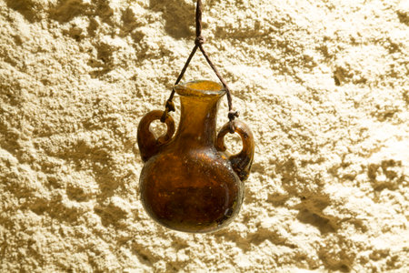 Jar of dark glass on the background of a concrete wall. Vintage bank. Extremely light. Bead glass on a shoestring.の写真素材