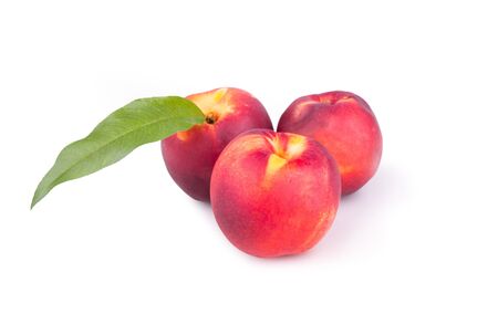 Three ripe peaches with leavesの写真素材
