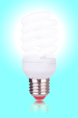 economical bulb glowing on blue backgroundの写真素材