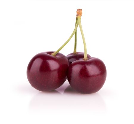 three ripe cherries on a white backgroundの写真素材