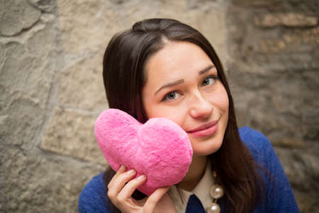 beautiful girl with plush pink heartの写真素材