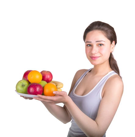 beautiful sports girl holding a bowl of fruitの写真素材