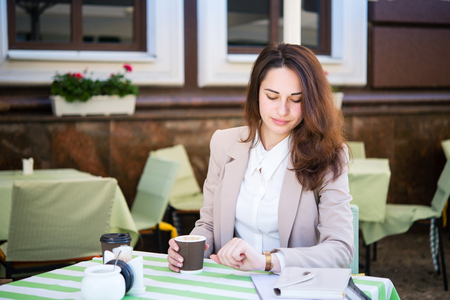 A beautiful business girl is waiting for someone during a business lunchの写真素材