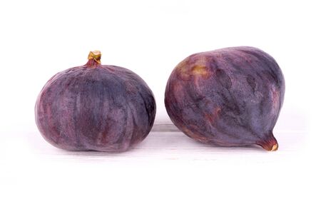 Two ripe close up figs on white wooden surfaceの写真素材