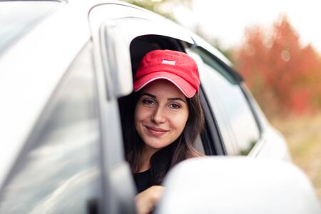 beautiful smiling girl driving with open windowの写真素材