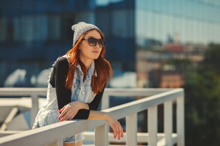 Outdoor fashion lifestyle portrait of pretty young girl, wearing in hipster swag grunge style urban background. Tomboy city conceptの写真素材