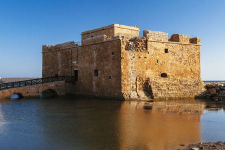 Old castle on Mediterranean sea coast. Paphos, Cyprus. Bright sunset lightの写真素材