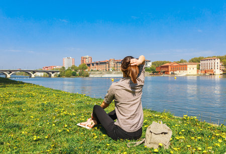 Tourist woman in French ancient town Toulouse and Garonne river. Toulouse is the capital of Haute Garonne department and Occitanie region, France, South Europe. Famous city and tourist destination.の写真素材