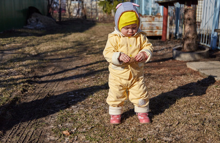 The little girl in a yellow jacket on walk keeps the cone