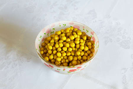 Tinned green peas lie in a small plateの写真素材