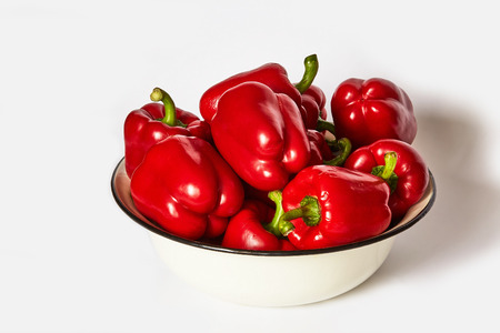 Many red pepper lie in a basin