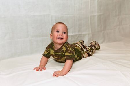 The Little boy in camouflage clothes leit on a white background