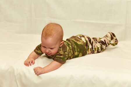 The Little boy in camouflage clothes leit on a white backgroundの写真素材
