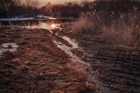 The road to the lake / river during the first autumn frosts or during the spring thaw