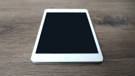 Tablet on the Wooden Texture Mock Upの写真素材