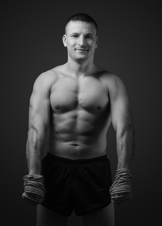 Muscular fighter Muay Thai fight warming up before a workout or at the hands of hemp rope. Black and white styleの写真素材