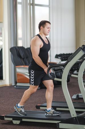 Young athlete running at the gym on the treadmill