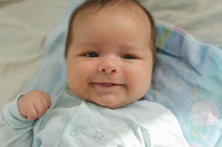 Beautiful newborn baby smiling and laughing. Soft focusの写真素材