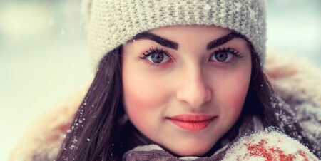 Happy young girl winter portrait in the snow. Close up of the face with water droplets on the eyebrows.の写真素材