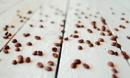 Roasted coffee beans spilled on a white wooden table. Beautiful  background.  Soft focusの写真素材