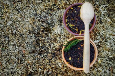 Two pots of black tea with herbs with wooden spoon on the rustic wooden  background. Top of view. Organic food, healthy lifestyle.の写真素材