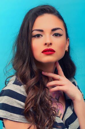 Close-up portrait of the beautiful attractive young woman  on the blue vintage  background. Young female model.の写真素材