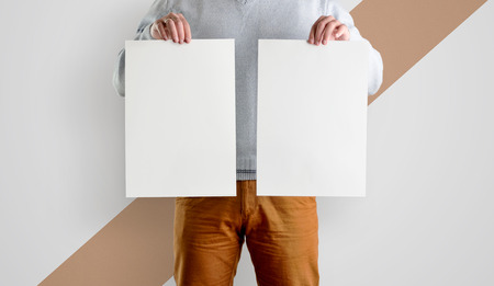 Two Template mocup posters in the hands of men. White forms of a flyer in hand, isolated against a background with a diagonal strip.の写真素材