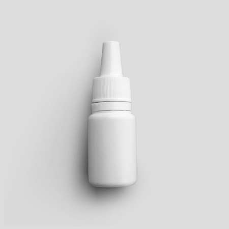 Mockup white matte bottle with dropper for medicine, liquid for treatment of nose, eyes, ears, plastic vial for design presentation. Container template with pipette Isolated on backgroundの写真素材