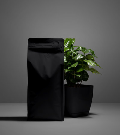 Template of black matte pouch with valve, green Arabica tree in a pot, zip package of coffee with shadows on the background. Product photography for advertising. Mockup doy pack for design, branding.の写真素材