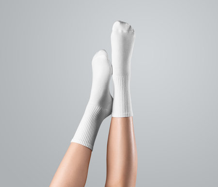 Template of white high socks on women's feet, legs up presentation, front view, isolated on background. Mockup of gaiters on feet with long elastic band, for design, pattern, printの写真素材