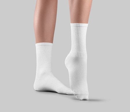 Template of white high gaiters on women's legs, one foot with stretched toes, side view, for design. Mockup of pair apparel on ankle, long elastic band on socks, isolated on background.の写真素材