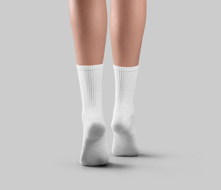 Mockup of white high socks on tiptoes, back view, long clothes on women's beautiful ankles, for design, branding. Fashionable footwear template, pair of gaiters on feet, isolated on backgroundの写真素材