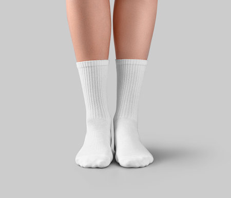 Template of white high socks on women's beautiful feet, front view, high elastic band on gaiters, isolated on background. Mockup of clothes on feet, for design, branding, pattern, print, advertisingの写真素材