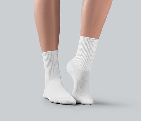 Mockup of white medium socks on women's feet on tiptoes, isolated on background, side view. Template of fashionable gaiters with elastic band, for design. Pair of apparel on footの写真素材