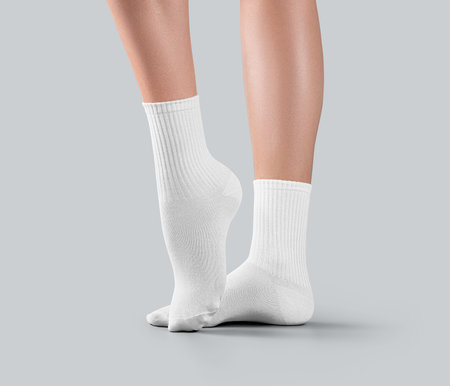 Mockup of white medium socks on women's stretched toes, isolated on background, side view. Stylish women's gaiters template with elastic average band on legs, for design, print, pattern, branding.の写真素材