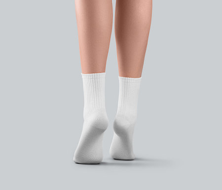 Mockup of white medium socks on women's feet on tiptoes, for design, advertising, back view. Template of women's gaiters with elastic average elastic band on legs, isolated on background.の写真素材