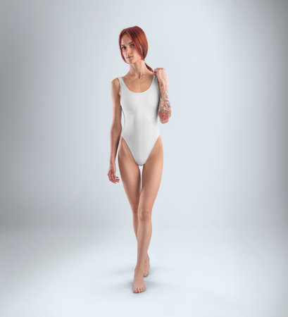 Mockup of a white sports swimsuit, one piece on a girl with a tattoo, in full height, front view, isolated on background. Underwear template for swimming, for design, branding. Product photographyの写真素材