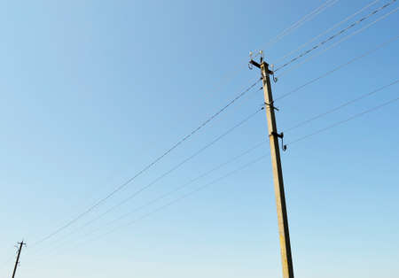 Power electric pole with line wire on colored background close up. Photography consisting of power electric pole with line wire under sky. Line wire in power electric pole for residential buildings.の写真素材