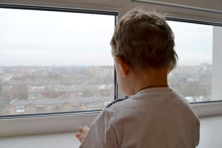 Beautiful baby boy with child face posing photographer near window for color photo. Cadre consisting of baby boy in child image near window, caucasian expression. Healthy baby boy it child near windowの写真素材
