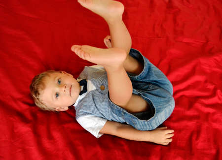 Beautiful baby boy with child face posing photographer for color photo. Cadre consisting of baby boy in child image, caucasian expression face. Healthy baby boy in child face relaxing for good shot.の写真素材
