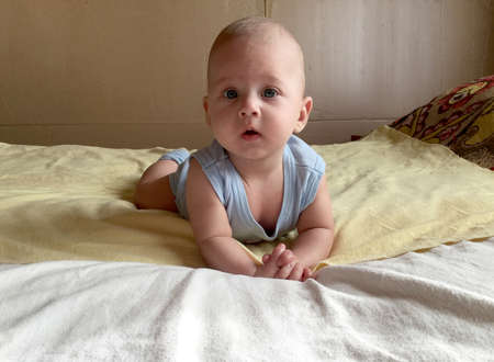 Beautiful baby boy with child face posing photographer for color photo. Cadre consisting of baby boy in child image, caucasian expression face. Healthy baby boy in child face relaxing for good shot.の写真素材