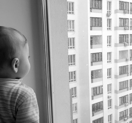 Beautiful baby boy with child face posing photographer near window for color photo, cadre consisting of baby boy in child image near window, caucasian expression, healthy baby boy it child near windowの写真素材