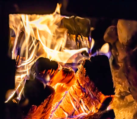 Beautiful old fireplace with light flame fire for heating building room, old fireplace consisting of...