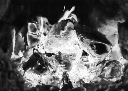 Beautiful old fireplace with light flame fire for heating building room, old fireplace consisting of thick oak wooden logs in hot flame fire, bright flame fire in old iron fireplace from slice treeの写真素材